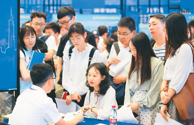 越来越多的年轻人被企业“抢人大战”吸引，选择居住地时考虑更加全面、标准更加多元。图为江苏南京第32届高级人才交流洽谈会上，求职者（右）在与用人单位代表洽谈。 刘建华摄（人民视觉）