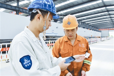 图①工地上的安全员用手机app扫卡进行安全违章扣分.