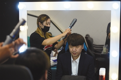 化妆师给教练“奶茶”化妆。9月9日，电竞手们要出席一个与游戏迷的见面活动，商业化是目前电竞俱乐部一个重要的盈利方向。
