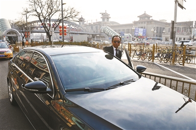 滴滴礼橙专车司机郑军在北京站附近等候乘客 摄影/本报记者 黄亮