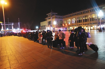 2月15日晚11时30分，北京站大批乘客出站后排队等待乘坐出租车