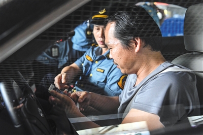 去年5月，广州市交通委员会执法局执法人员在广州东站对网约车相关资质进行核查。资料图片/视觉中国