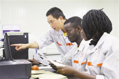 近日，在中国—乌干达国际产能合作工业园的仪器分析室里，中乌两国科研人员在对当地的矿石样品进行分析。本报记者 吕 强摄