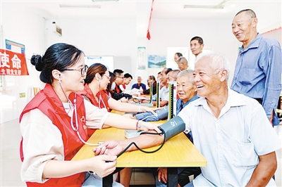 湖州长兴县中医院医共体集团志愿者为老人免费测血压。资料图片