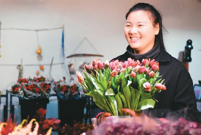 在河南郑州小马进口鲜花店，臧晶晶手捧郁金香鲜花。