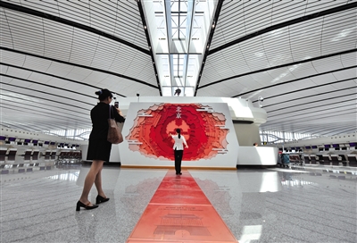 9月25日，一位女士在机场中轴线标尺前留影。 新京报记者 李木易 摄