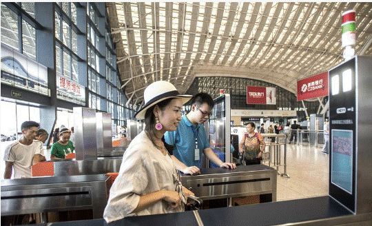 ▲在中国武汉火车站，一名乘客通过一扇装有人脸识别系统的大门。（新华社）