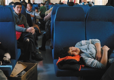 k4051次列车车厢温度上升,乘客纷纷脱去厚衣,一名女孩躺在空的硬座