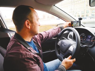 网约乘客上车后，司机叶甫盖尼在打车软件的界面上进行操作。