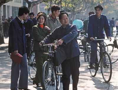 上世纪80年代，南京路上市民或推或骑着老式“二八”自行车。