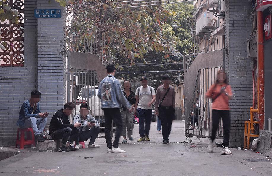 3月16日下午,广州市白云世界皮具贸易中心旁桂花岗小区。记者连续多日观察后发现,该小区的几个入口和内部,长期有拉客人员和望风看场子的人员聚集。 新京报记者 吴江 摄
