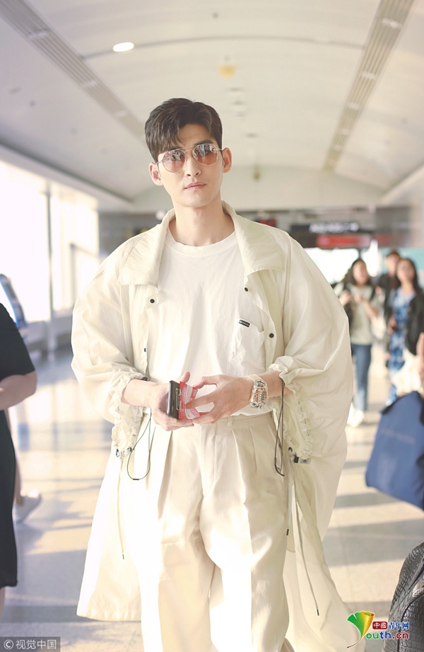 张翰穿白色风衣走路带风 翻看粉丝手记眼角笑出褶