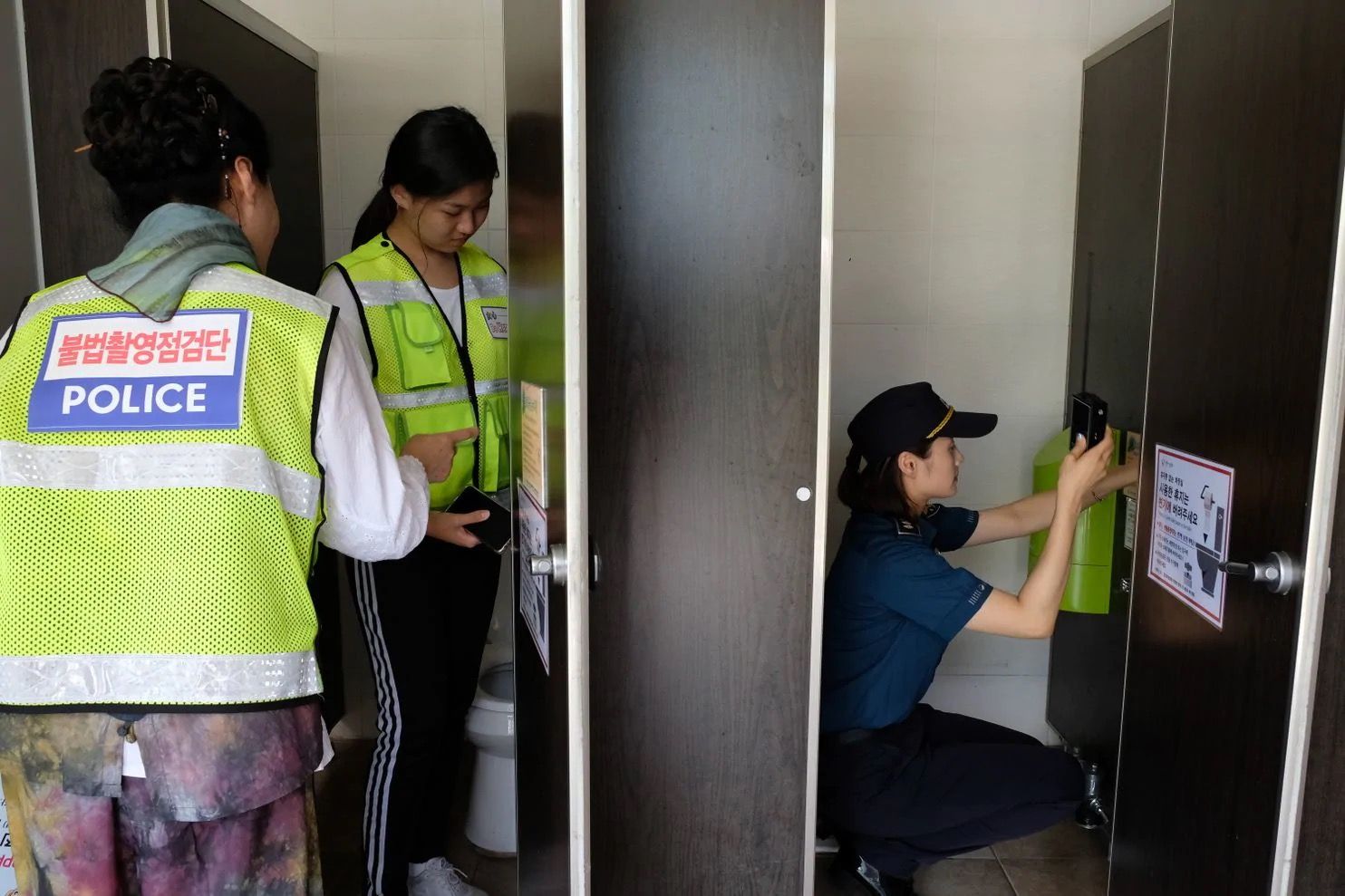 韩国女警在公共厕所里用探测仪排查偷拍摄像头.