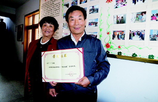  范广祥向记者展示他获得的“最美家庭”证书。　本报记者　路龙帅　摄