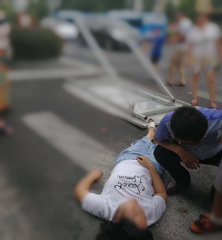 大风刮倒指示牌她推开孩子自己却被砸晕
