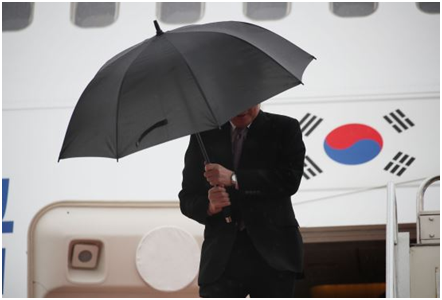  强风袭来，李洛渊双手紧握雨伞 图源：《国民日报》