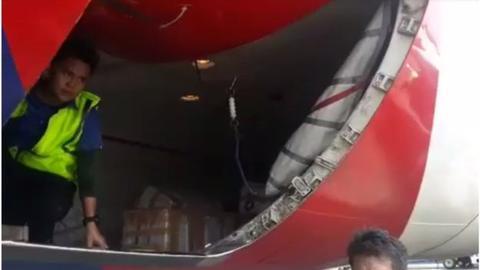 工作人员将机上的榴莲从货舱卸下。（BBC）