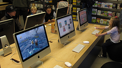 资料图片：在美国纽约曼哈顿第五大道的苹果专卖店，顾客在试用苹果电脑。（新华社）