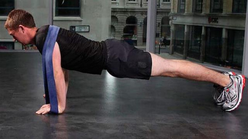 同样的,做俯卧撑时,增加一根弹力带,也可以降低难度,辅助完成俯卧撑