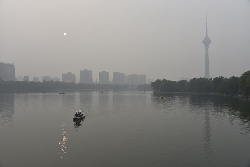  10月19日，北京陷入一片霧霾之中，從玉淵潭公園看中央廣播電視塔和太陽。   ICphoto 圖