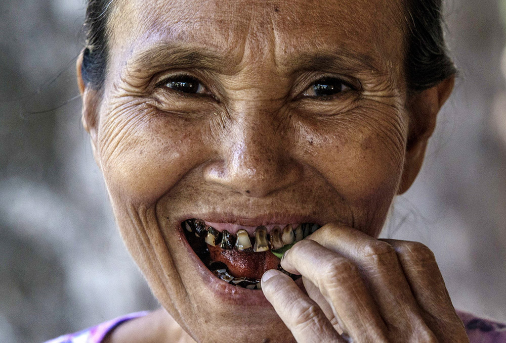 九十年代,越南河内,一名年轻男子与家人坐着三轮车,抱着一盘槟榔果