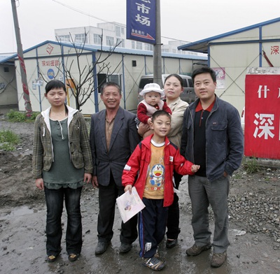 青年奥运会开幕式 2009年5月8日,四川省什邡市,在地震中受灾的徐兴蓉全家在自家板房小区门口。2008年8月8日,徐兴蓉在什邡产下“奥运宝宝”。张晓理/摄