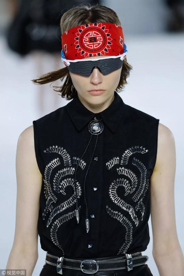 一眼可见的是模特带着毛球装饰的曲别针耳环,仔细看衣服上半部分金属