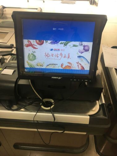 乐天超市上地店的收银台屏幕已显示物美logo