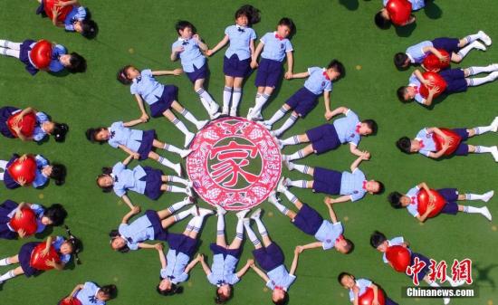 资料图：江苏扬州一幼儿园组织即将毕业的孩子们在操场上摆出创意新颖的图案拍摄个性毕业照，留下独特的美好回忆。孟德龙 摄