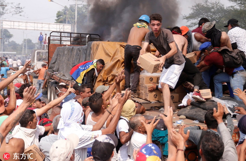 　反对派支持者从一辆着火的卡车上卸下“人道主义援助”物资。（图源/东方IC）