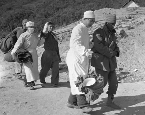 ▲资料图片：1962年12月5日，西藏地方边防部队在邦迪拉释放了向我边防部队发动进攻而被俘的印军伤病人员64名。图为中国医生和护士搀扶被俘印军人员走向印度红十字会派来的汽车。（新华社）