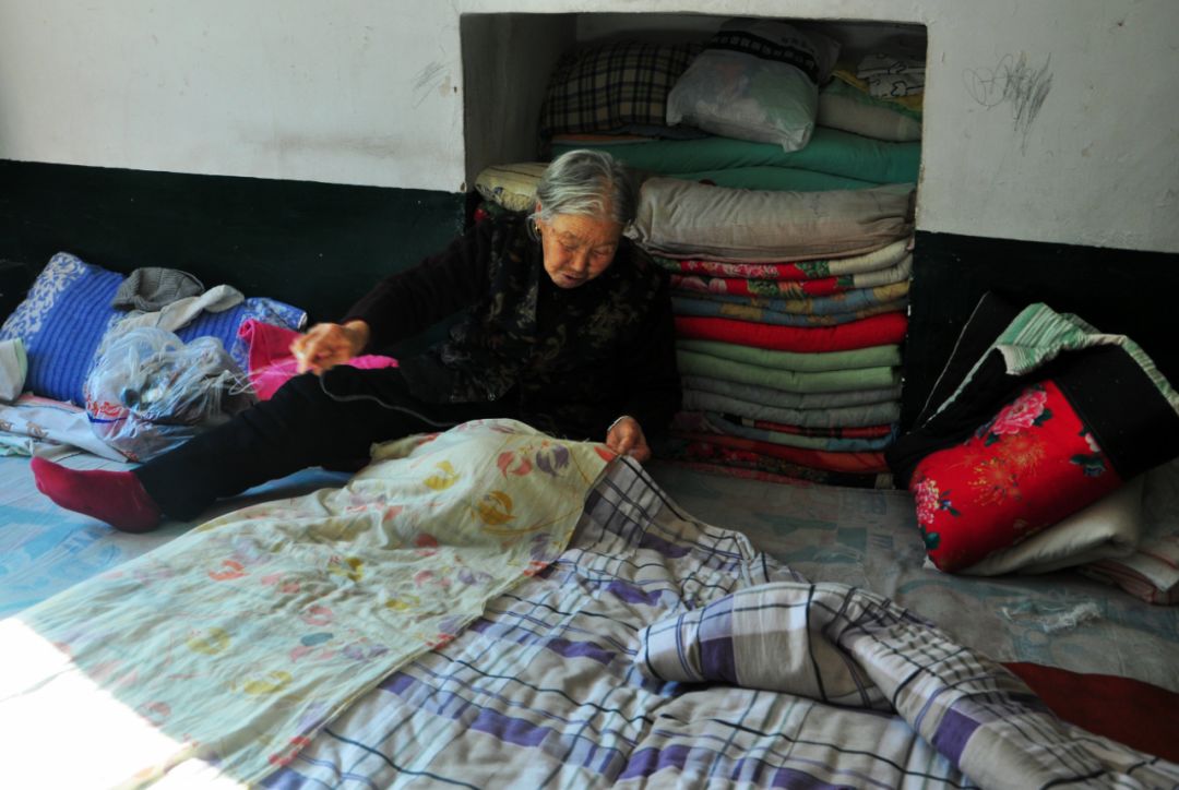 2018年1月18日,山西省忻州市.花甲老太太缝被子褥子面等着儿女回家.