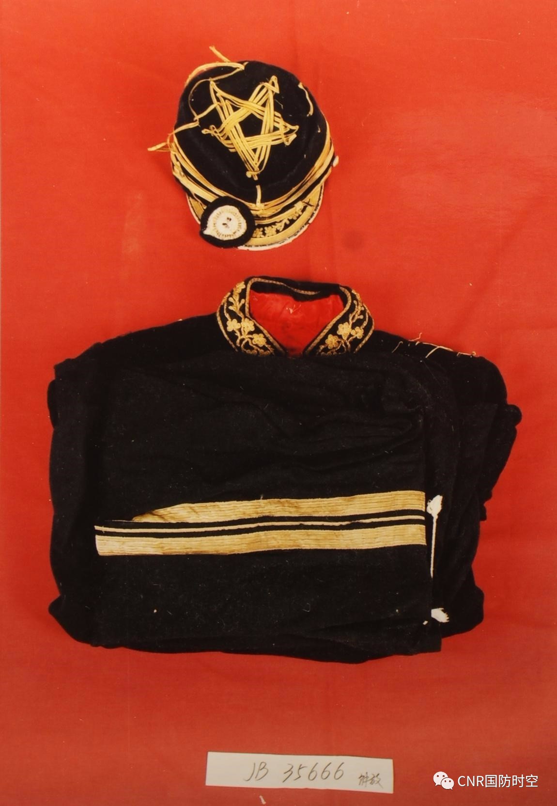 这是一套黑色呢质的国民党陆军三星上将军服,帽沿上方缀有青天白日