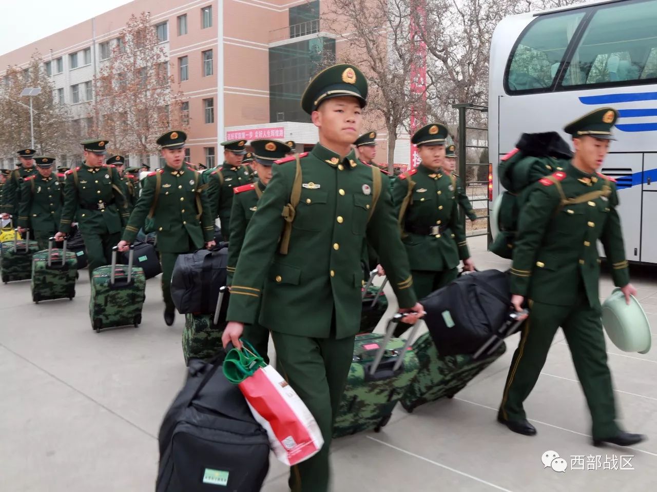 经过三个月封闭集训的新兵,背着背囊,提着行李从武警宁夏总队新训团来