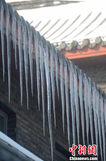 江苏扬州大雪后气温下降屋檐下冰凌犹如卷珠帘