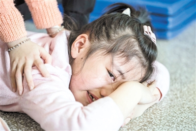 耐不住压腿的疼痛,小姑娘呜呜地哭了.