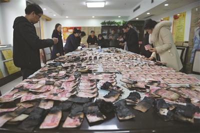 男子将40万现金藏冰箱不料一半被烧残币铺满桌子