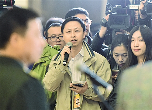 左图 经济日报·中国经济网记者顾阳在"委员通道"向赵红卫委员提问.