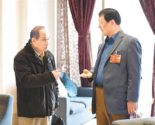 全国政协委员杨正国(右)在驻地和医学专家探讨脑科学,大健康问题.