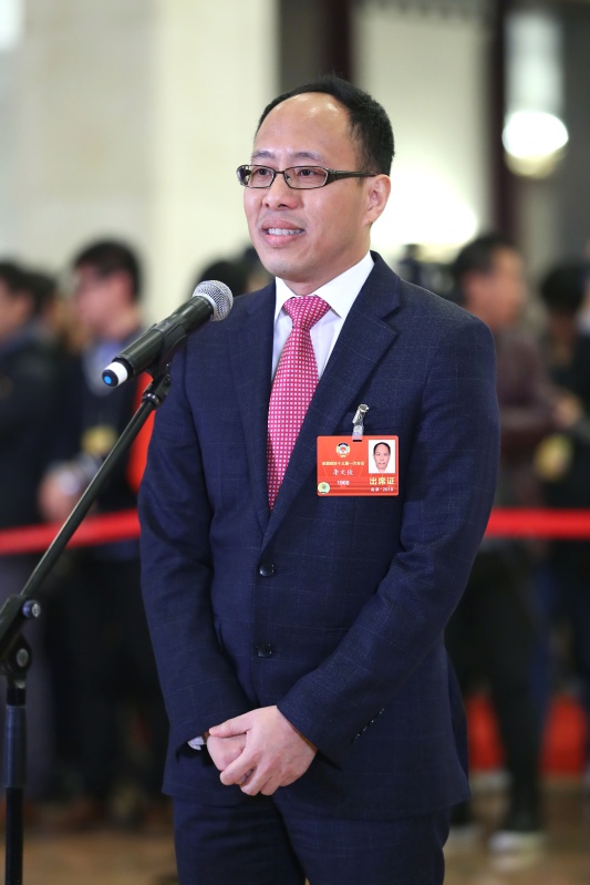 这是全国政协委员李文俊在"委员通道"接受采访