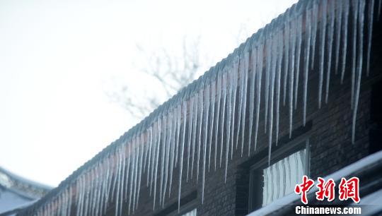 江苏扬州大雪后气温下降屋檐下冰凌犹如卷珠帘