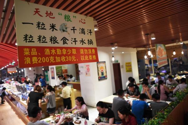 2017年6月9日,重庆市江北区观音桥商圈的一家自助餐厅内挂出提醒消费者“勤拿少取”的标语。新华社 资料图