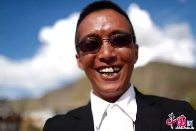 阿旺顿珠一身黑西服白衬衫派头十足