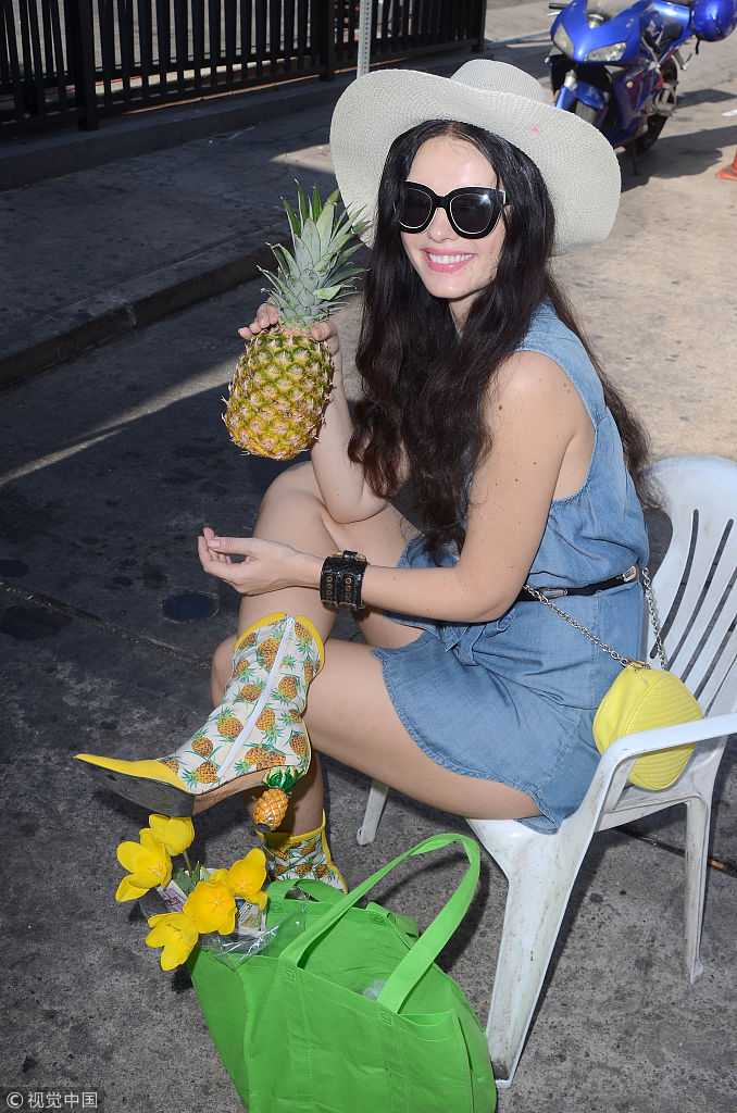 水果爱好者!辣模natasha手持菠萝凹造型 脚踩"菠萝"高跟获男子跟拍