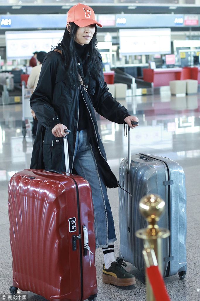 "大表姐"刘雯戴粉色棒球帽青春洋溢 推两大箱行李见偷拍低头偷笑