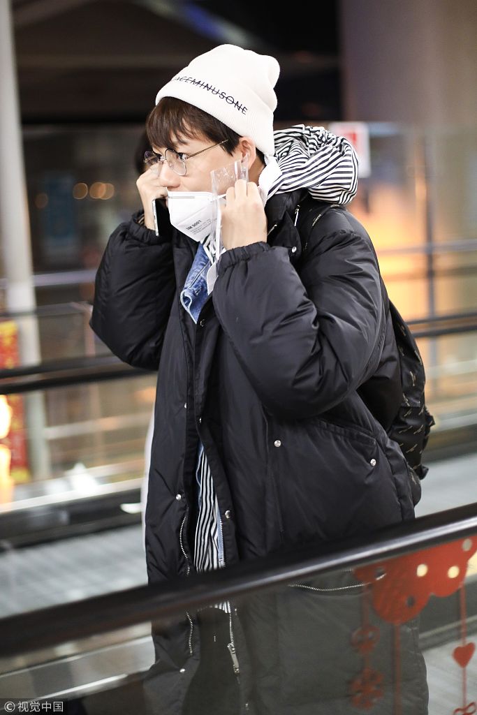 刘维捂嘴咳嗽似有恙戴专业口罩遮面裹长款羽绒服保暖抱胸接地气