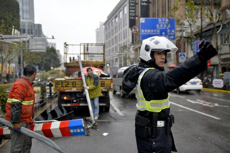 风雪夜上海交警增派50警力交通情况总体正常司机主动示意行人慢慢走