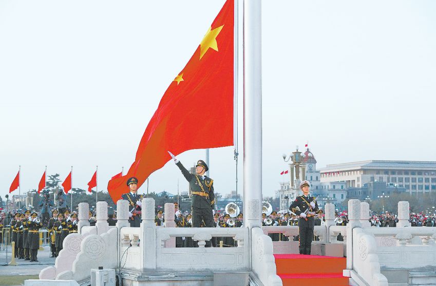 升旗手挥动右臂划出优美弧线,鲜艳的五星红旗迎风飘扬.