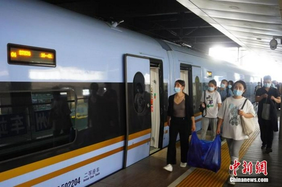 资料图:旅客在郑州火车站准备乘车。中新社记者 刘鹏 摄