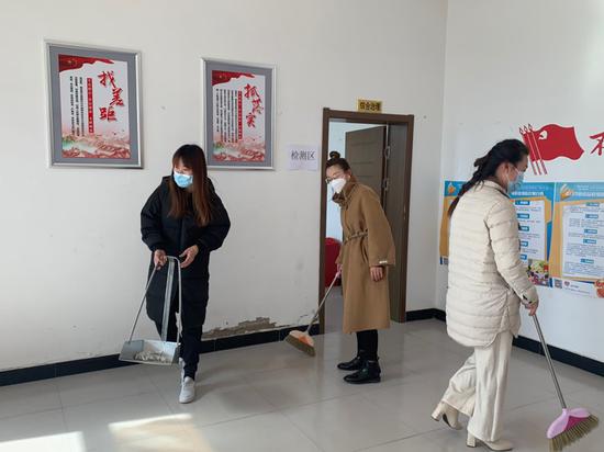 马坊村妇女志愿者打扫村部卫生